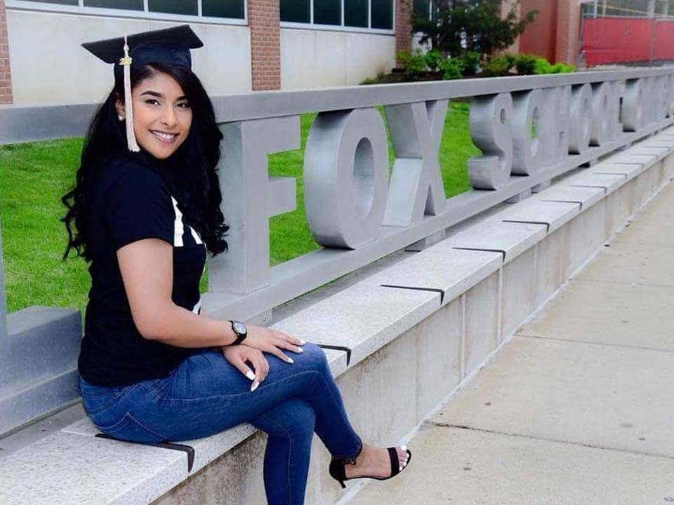 Woman sitting on bench with graduation cap
