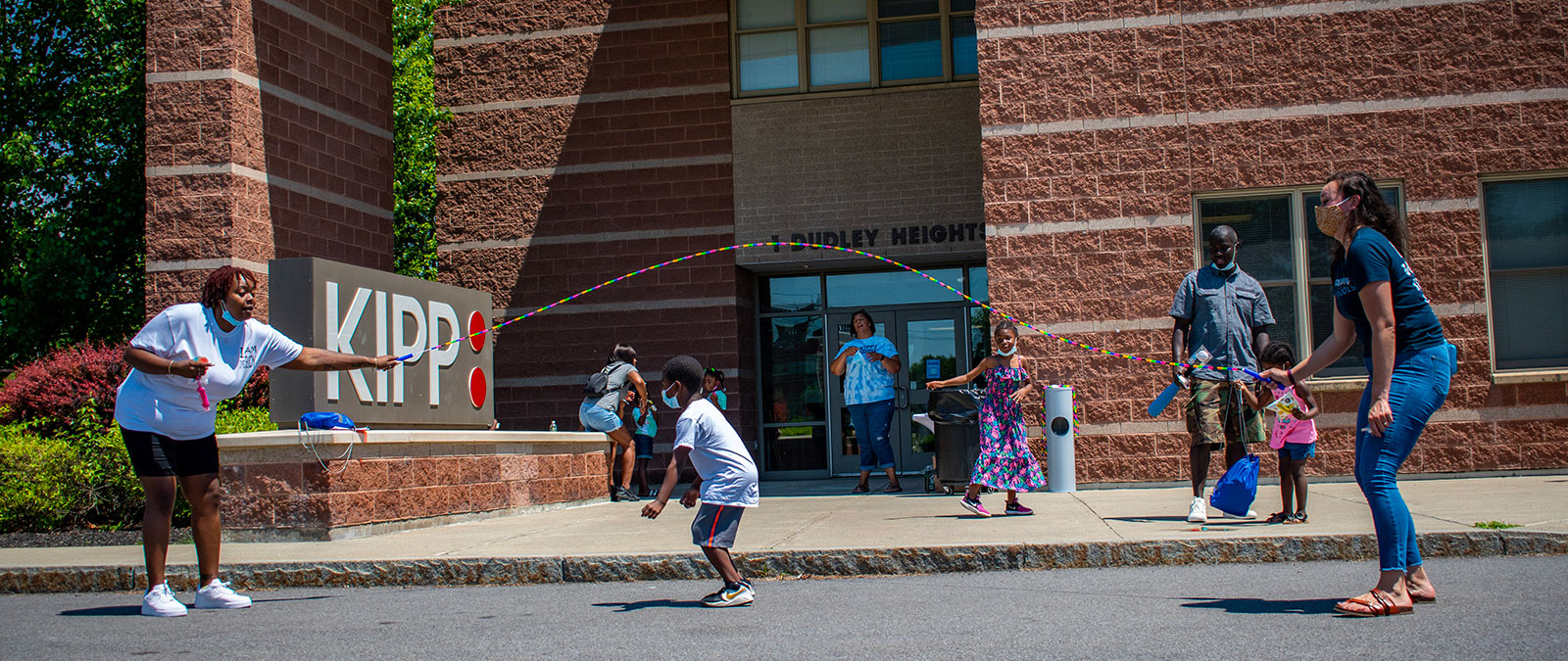 kids and teachers playing jumprope outside school